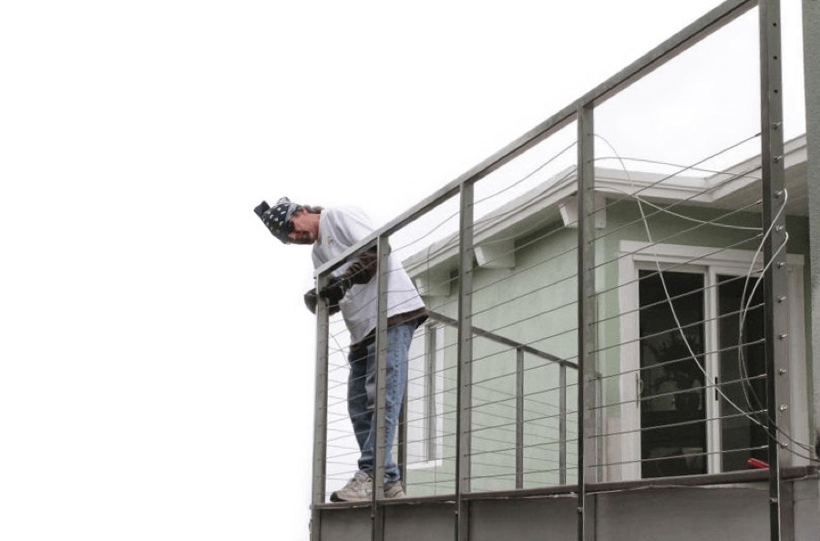 Tom Salas installing a cable railing on site